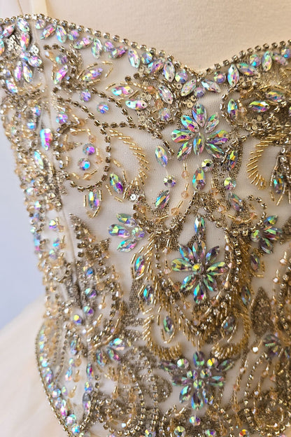 Dress detail of an ivory champagne kids mini quinceanera dress with layered glitter tulle fabric and detachable long train