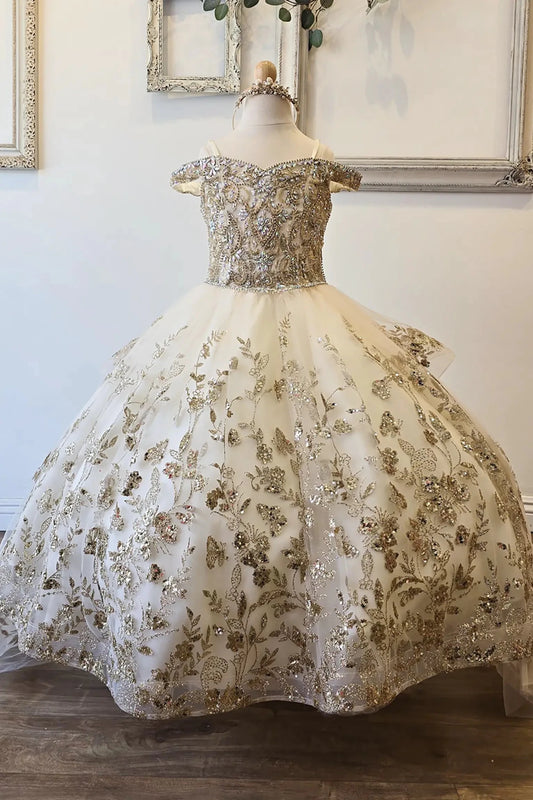 Front view of an ivory champagne kids mini quinceanera mini quince dress with gem-embellished bodice, glitter tulle skirt, and detachable train.