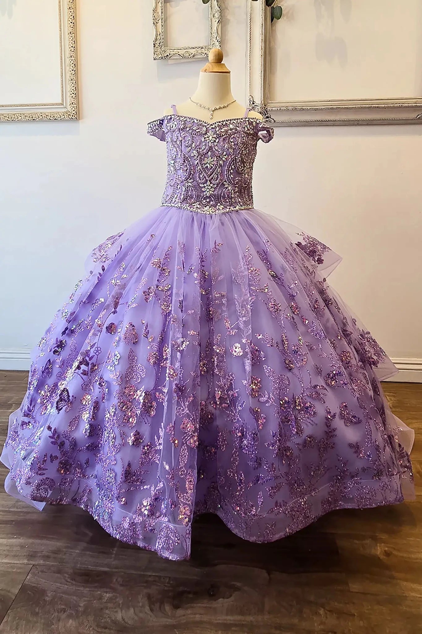 Front view of a lilac kids mini quinceanera mini quince dress with stone and gem-embellished bodice, glitter tulle skirt, and detachable train.
