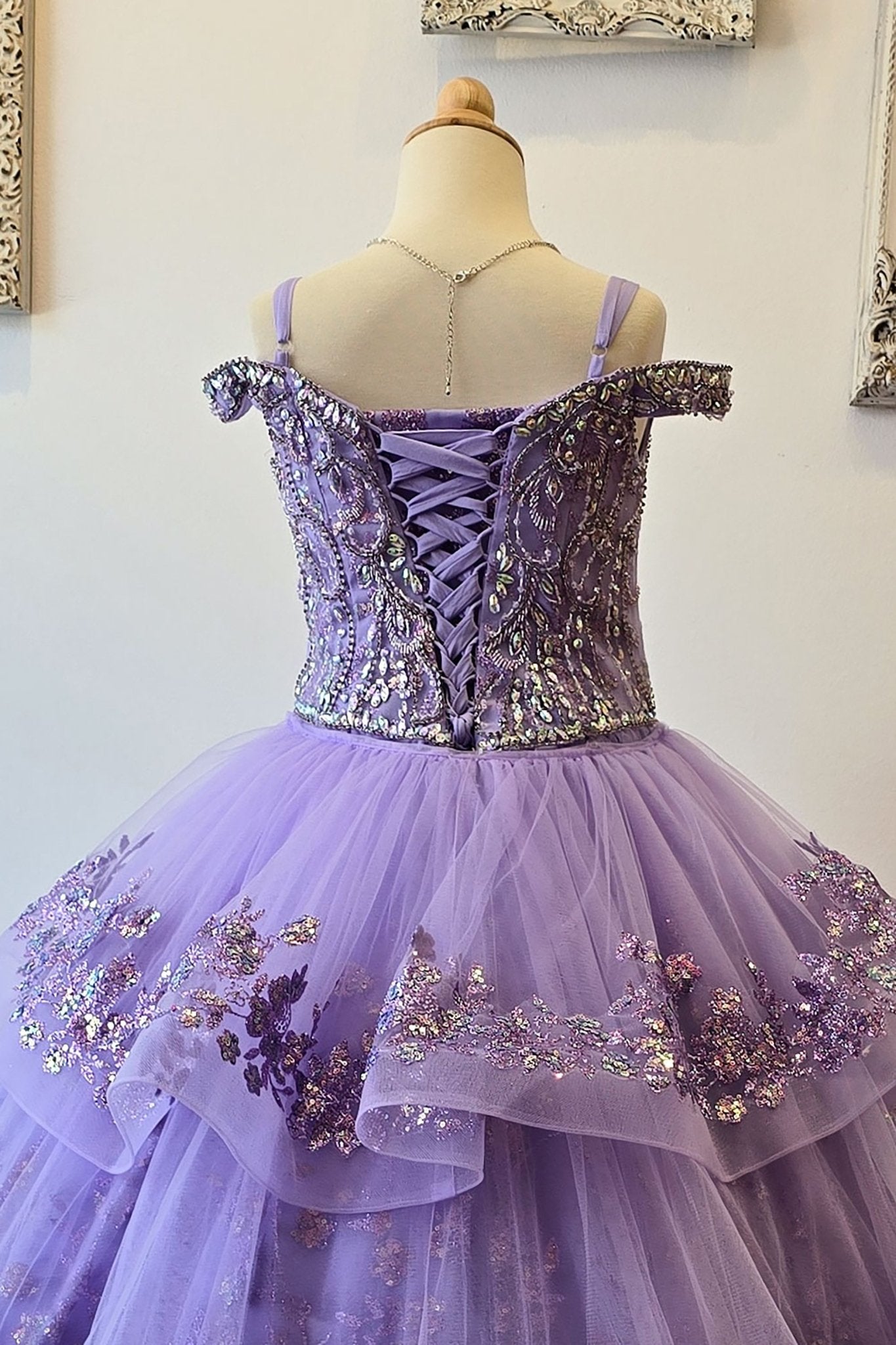 Zoomed back view of a lilac kids mini quinceanera mini quince dress highlighting gem-embellished bodice, floral detailing, and glitter tulle skirt.