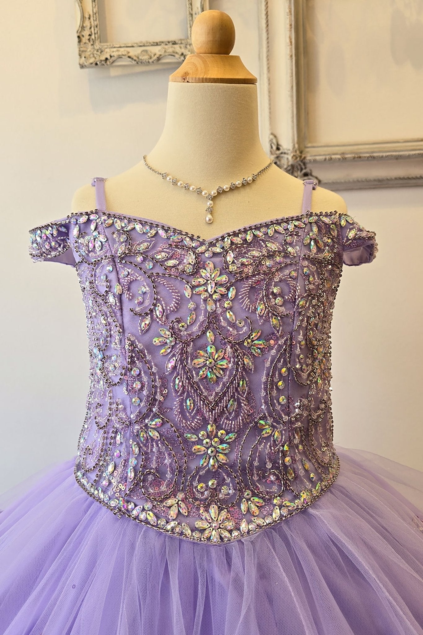 Zoomed front view of a lilac kids mini quinceanera mini quince dress highlighting gem-embellished bodice, floral detailing, and glitter tulle skirt.