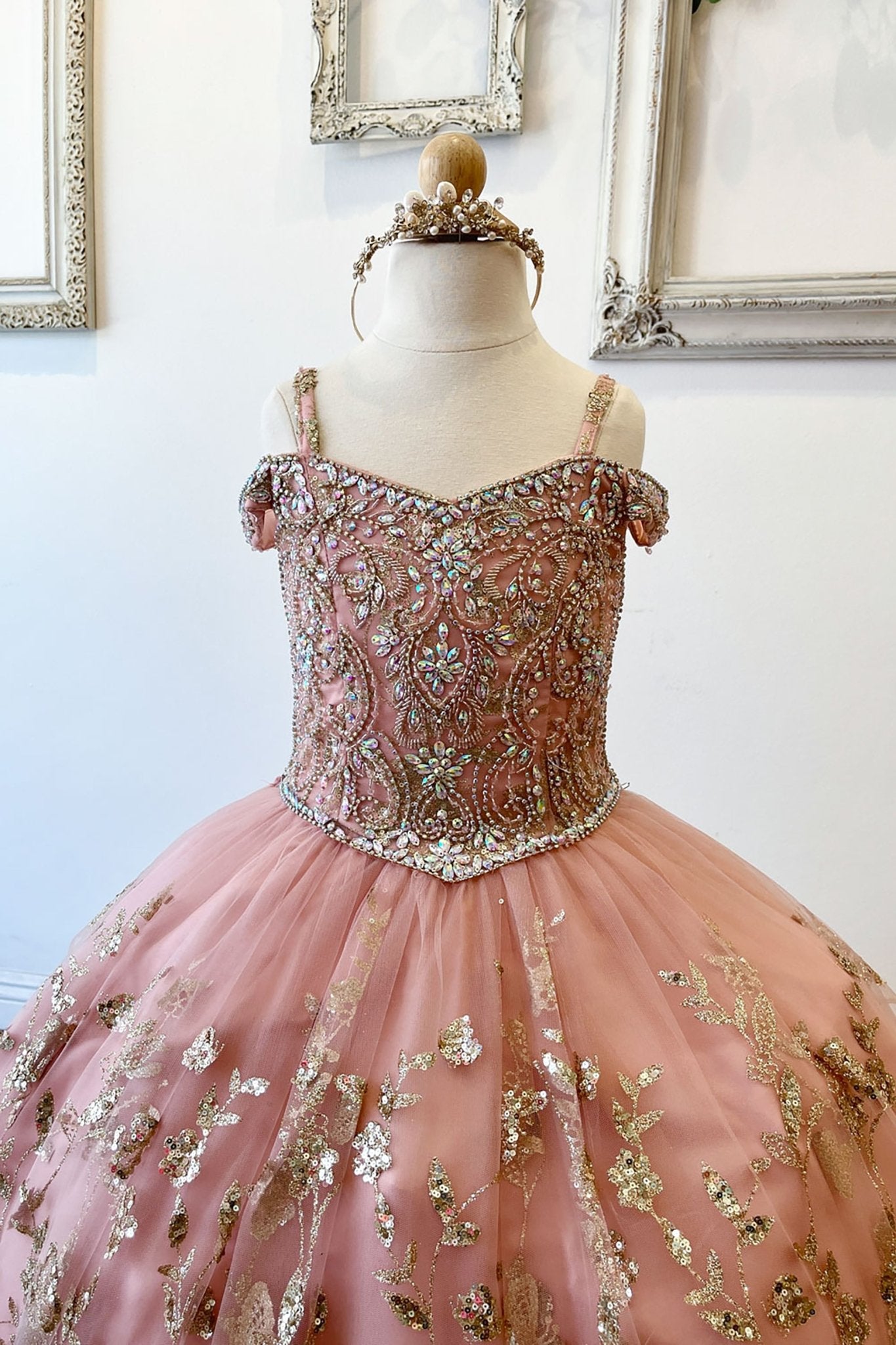 Half front view of a rose gold kids mini quinceanera mini quince dress highlighting gem-embellished bodice, floral detailing, and glitter tulle skirt.