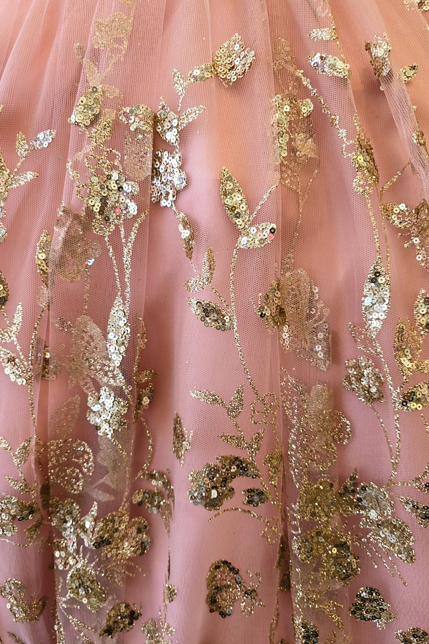 Skirt detail of a rose gold kids mini quinceanera mini quince dress with layered glitter tulle fabric and detachable long train.