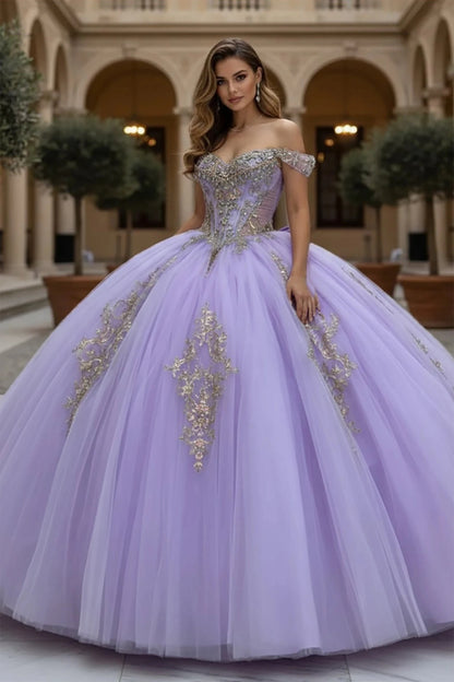 Woman wearing a lilac off the shoulder ball gown with gold embellishments in an elegant indoor setting.