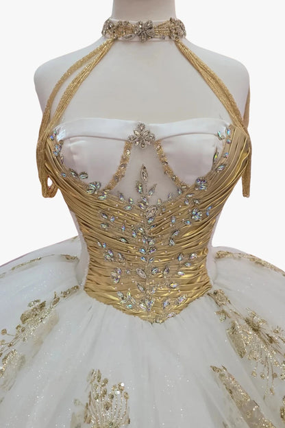 white ball gown with intricate detailing such as beautiful ab color stones with gold embroidery on a mannequin.