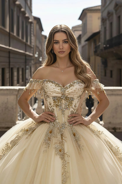 Girl in an ornate off-shoulder champagne dress with bead appliques and embroidery standing in an urban setting