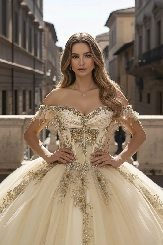 Girl in an ornate off-shoulder champagne dress with bead appliques and embroidery standing in an urban setting