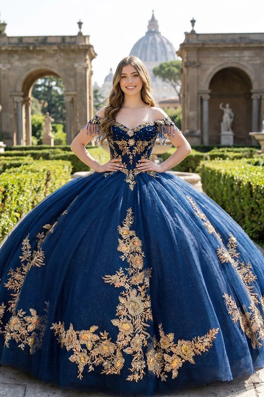 Girl in a navy and gold embroidery quinceañera ball gown standing in an outdoor setting with classical architecture.