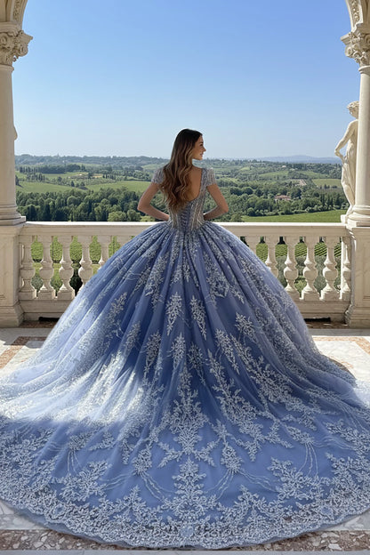 Woman in a blue lace ball gown dress with long train showing her back 
