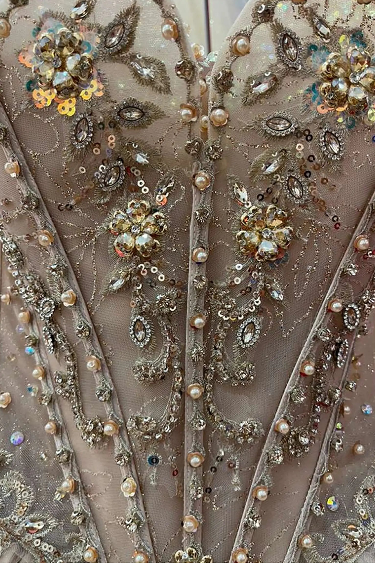 Champagne quinceañera ball gown richly embellished with sequins, jewels and radiant couture details