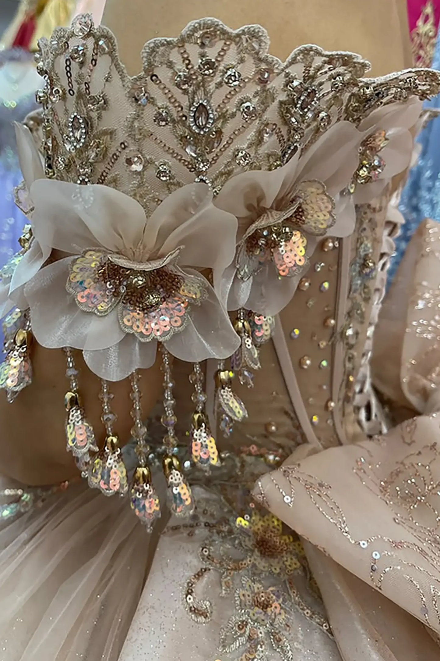 Champagne quinceañera ball gown featuring delicate floral off-shoulder sleeves and ornate embroidery