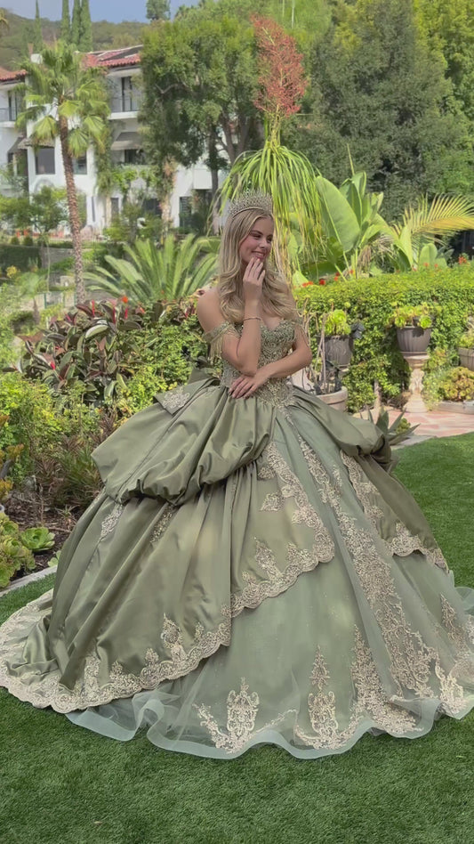 a girl wearing sage satin quince dress and tiara showing her back in a green garden. video