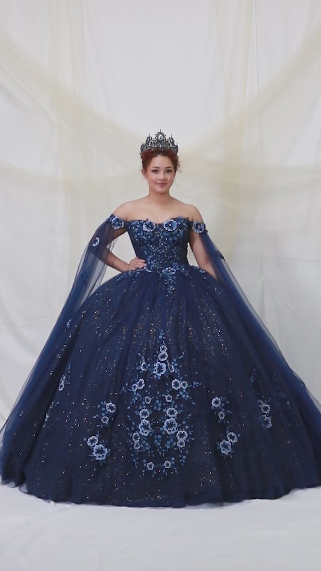 Video of Navy Quinceañera Dress with 3D Floral Applique, Detachable Sheer Cape and Glitter Tulle