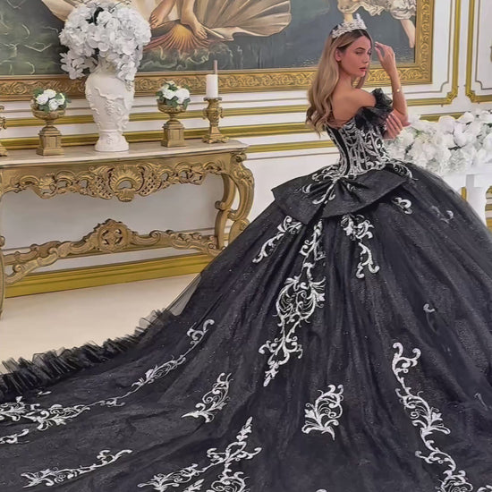 video of a girl wearing Black Ball Gown with Puff Sleeves, Butterfly Appliqués, and long detachable train.
