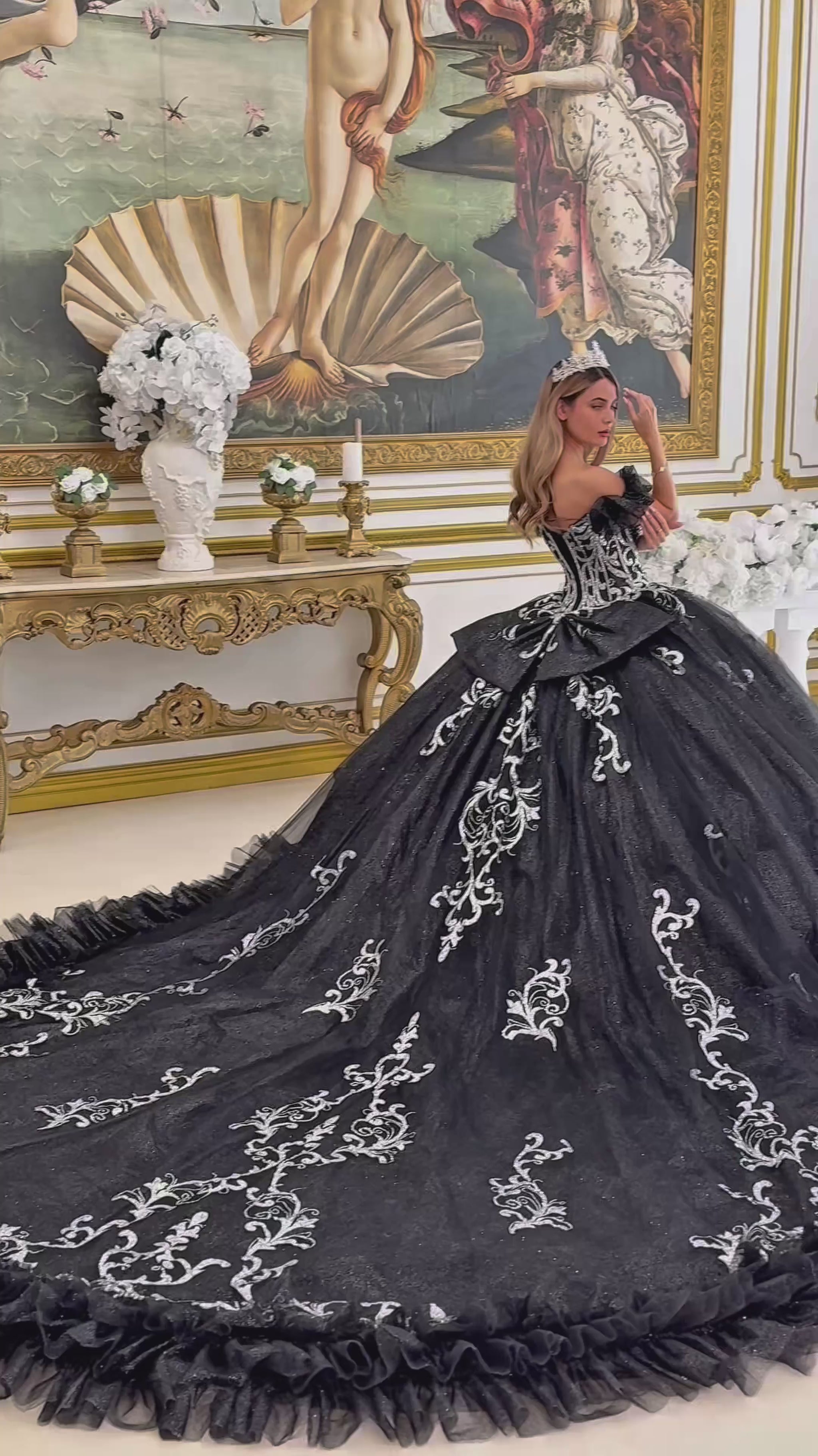 video of a girl wearing Black Ball Gown with Puff Sleeves, Butterfly Appliqués, and long detachable train.