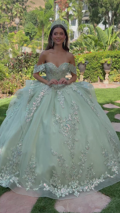 girl in a sage quinceañera dress with floral details standing outdoors. video