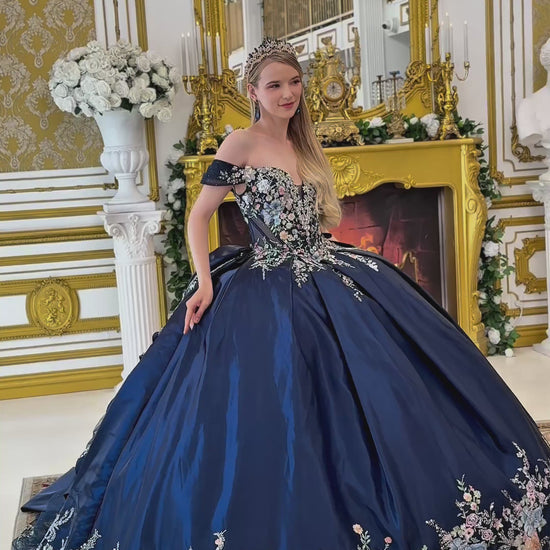a video of navy quinceañera dress showing floral embroidery on top of the dress and the bottom of the dress