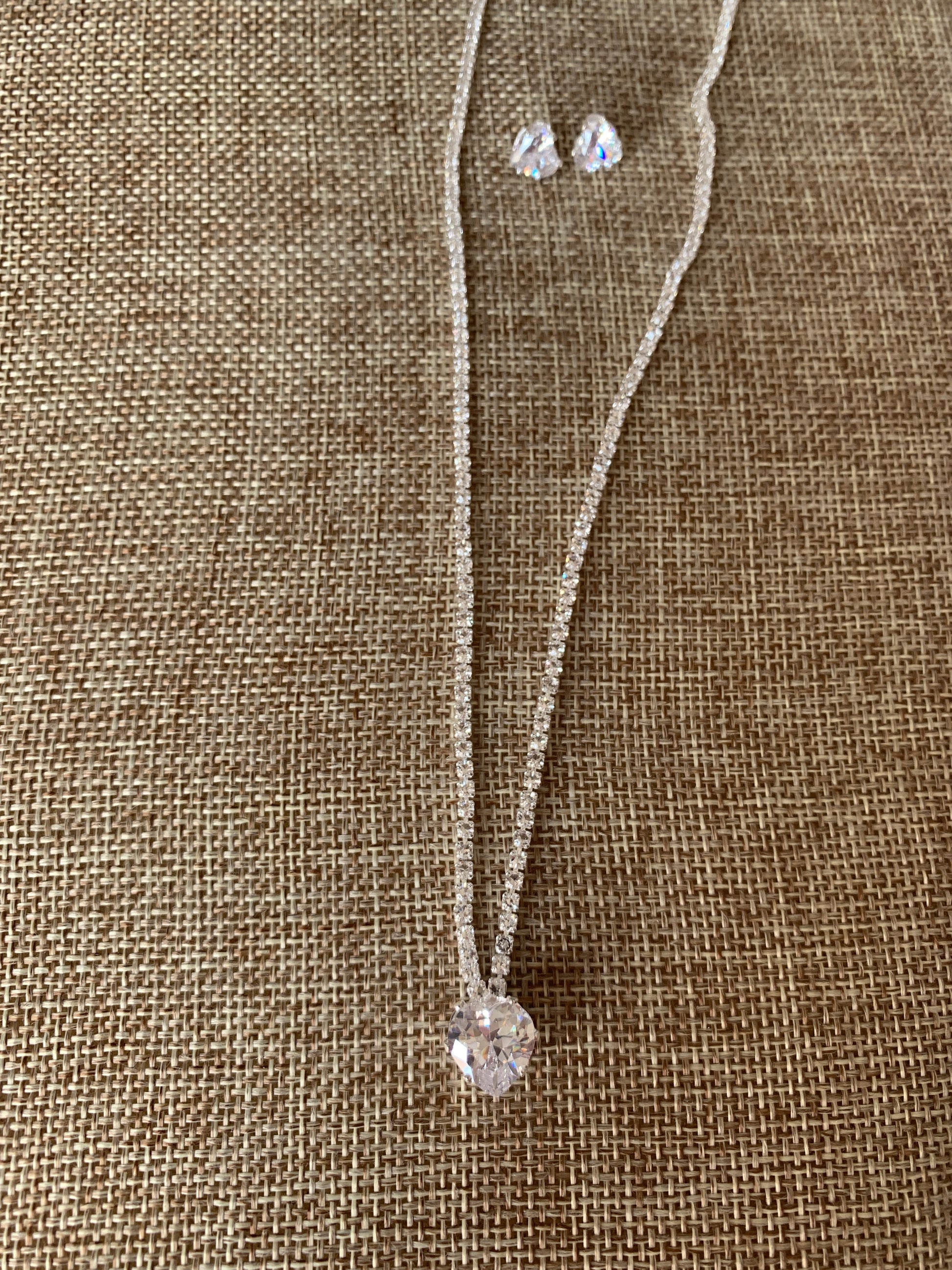 heart rhinestone necklace and earring on beige background