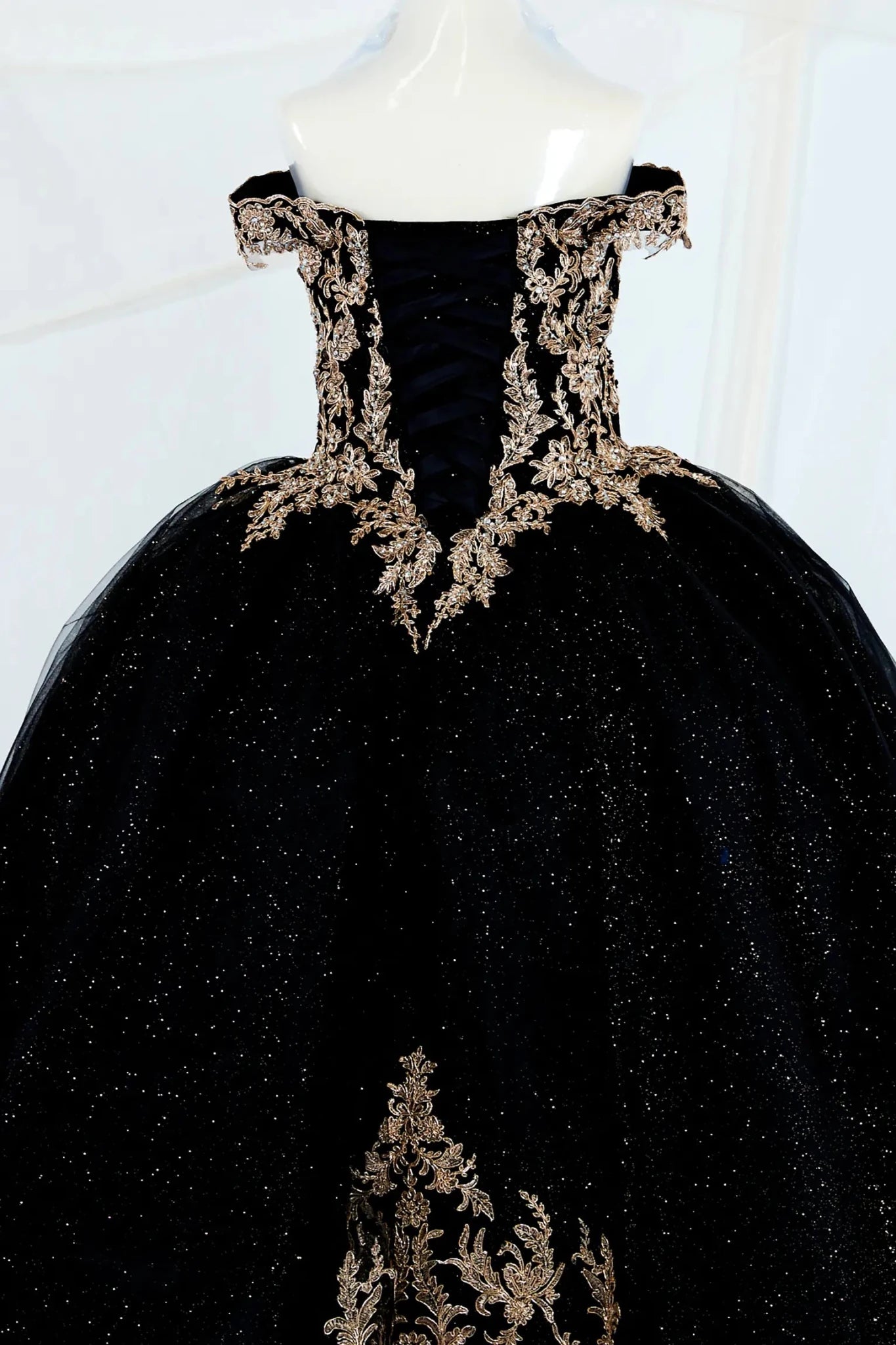 Black shiny tulle mini quince ball gown with gold embroidery showing the back of the mini quince dress, lace up back.