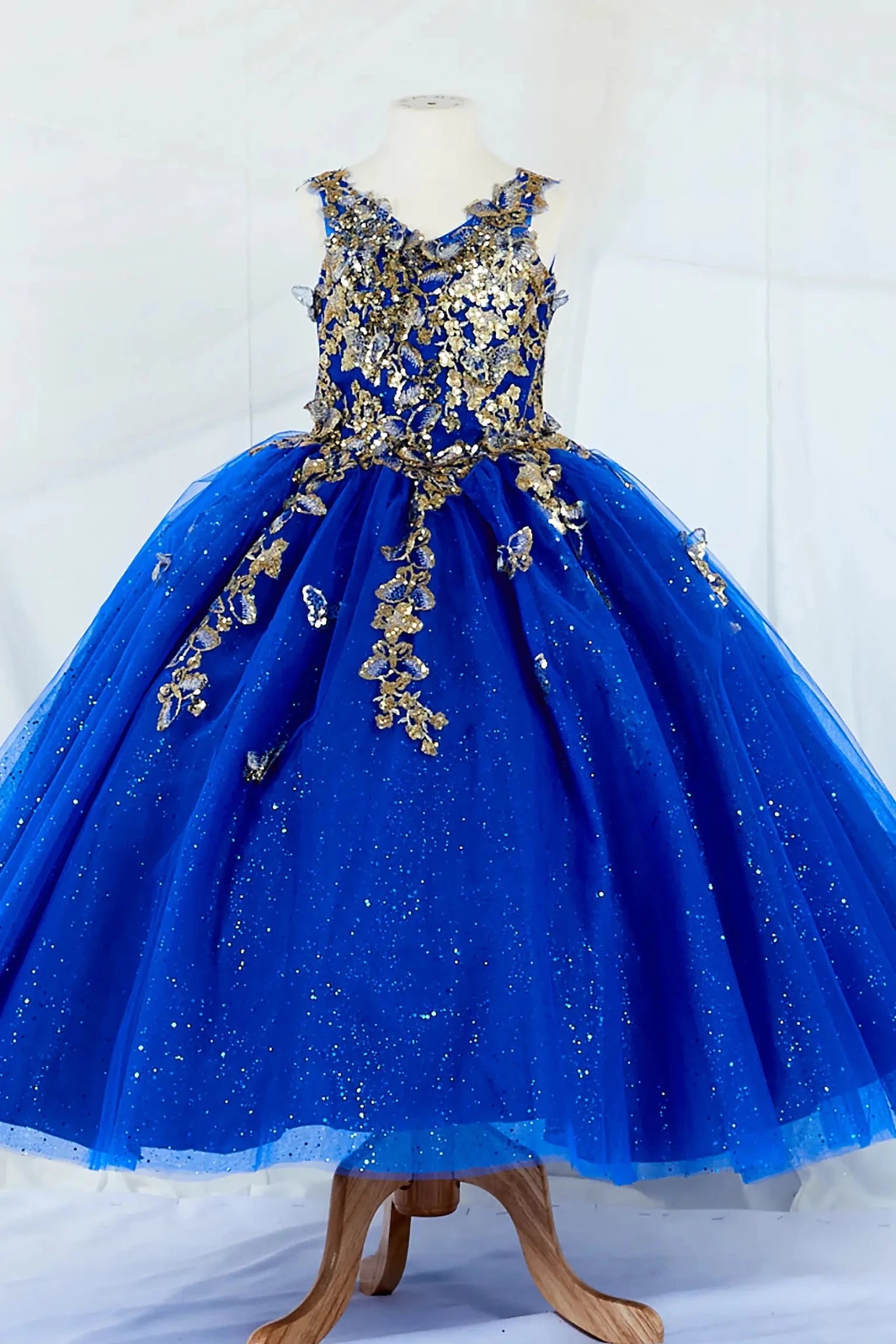 Front-facing in stunning royal blue mini quince mini quince dress with 3D floral appliqué bodice and glitter tulle layered skirt.