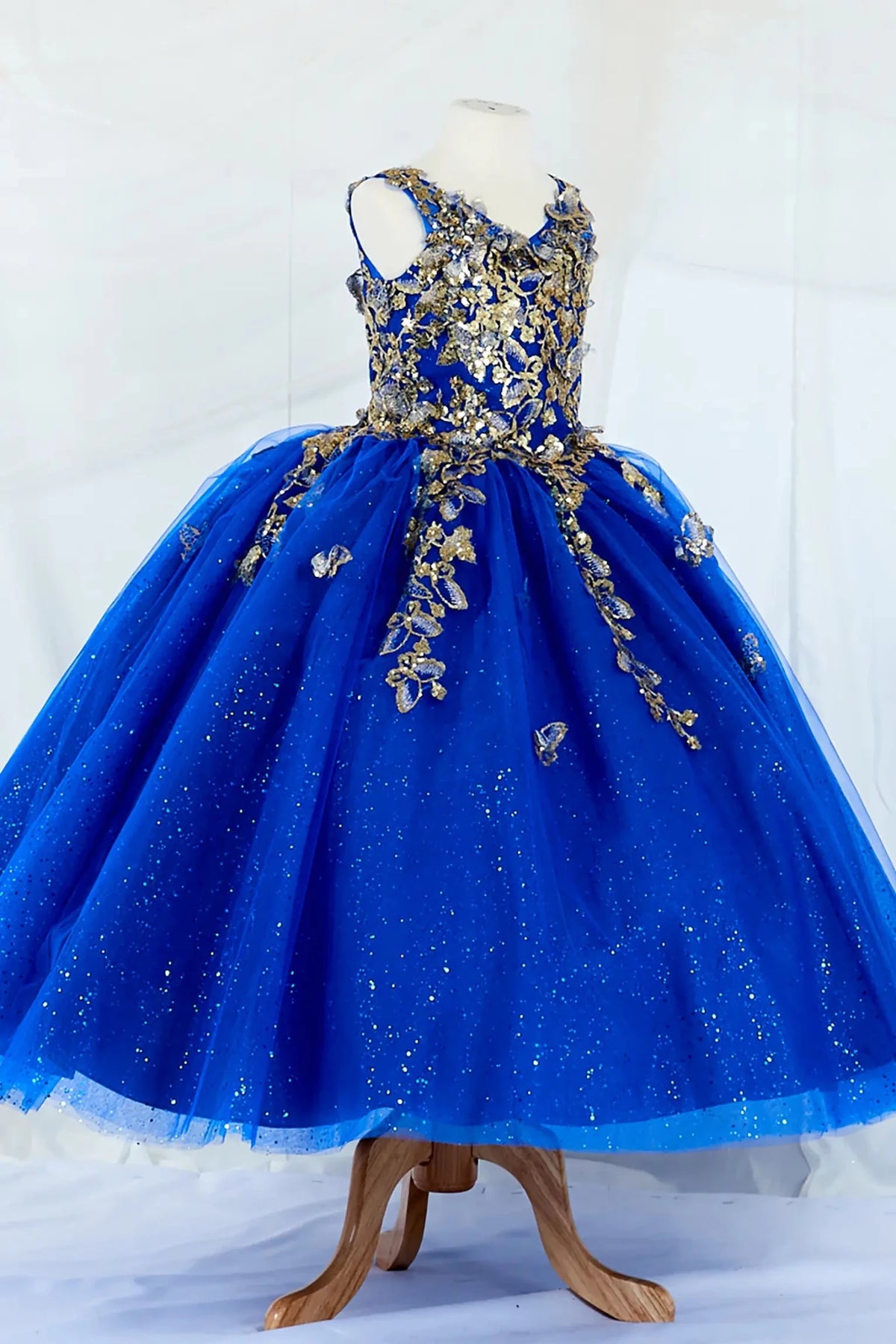 Side-facing in stunning royal blue mini quince mini quince dress with 3D floral appliqué bodice and glitter tulle layered skirt.
