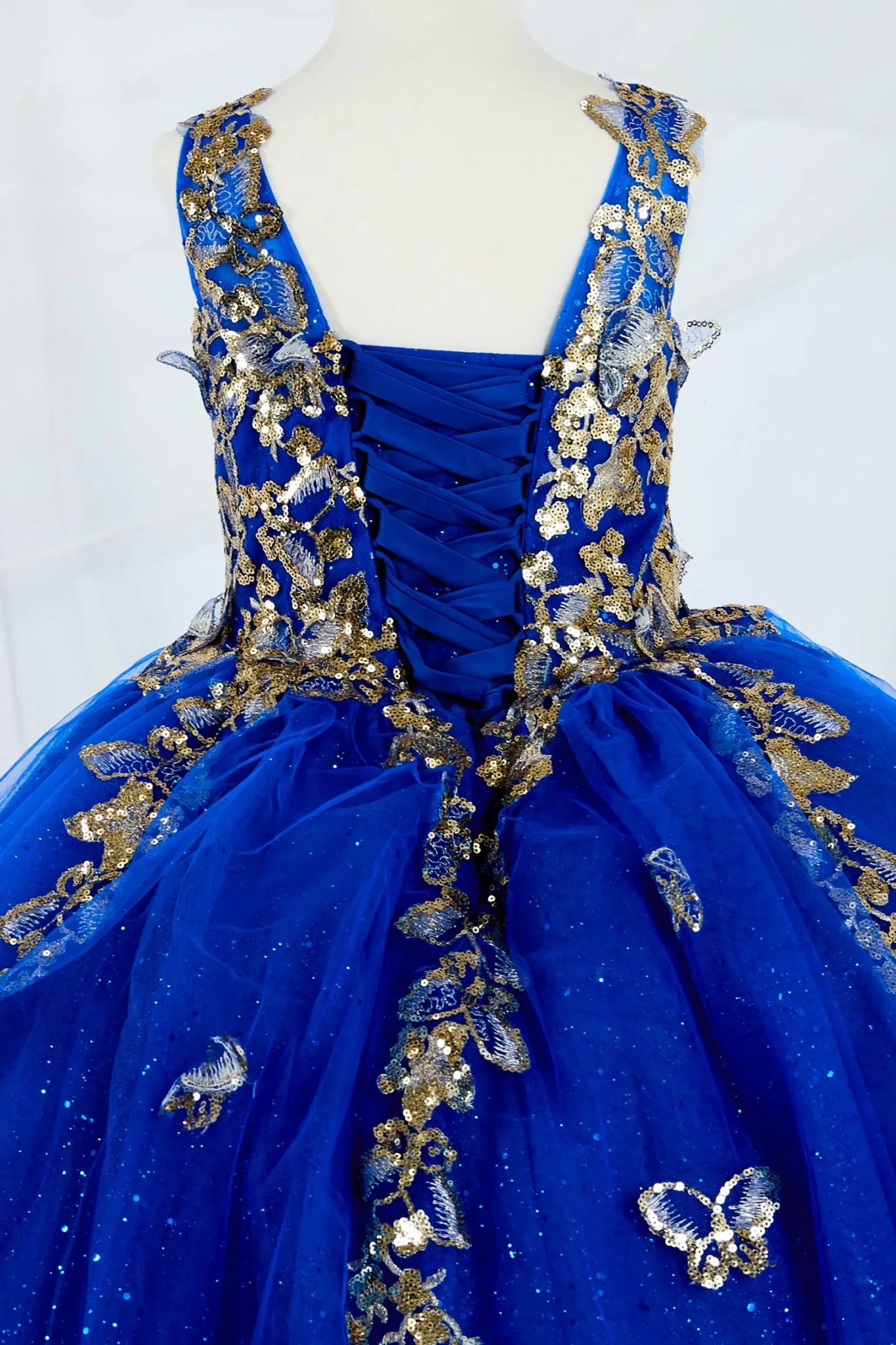 Back zoom ofstunning royal blue mini quince mini quince dress with 3D floral appliqué bodice and glitter tulle butterfly appliques.