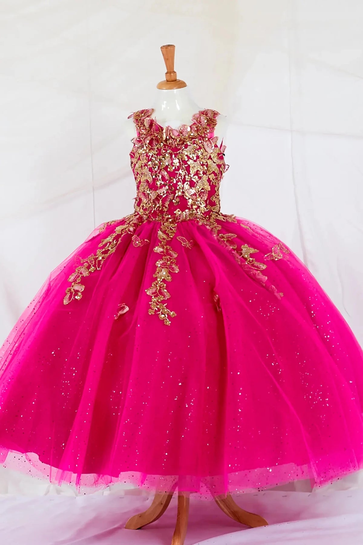 Front-facing in stunning fuchsia mini quince dress with 3D floral appliqué bodice and glitter tulle layered skirt.