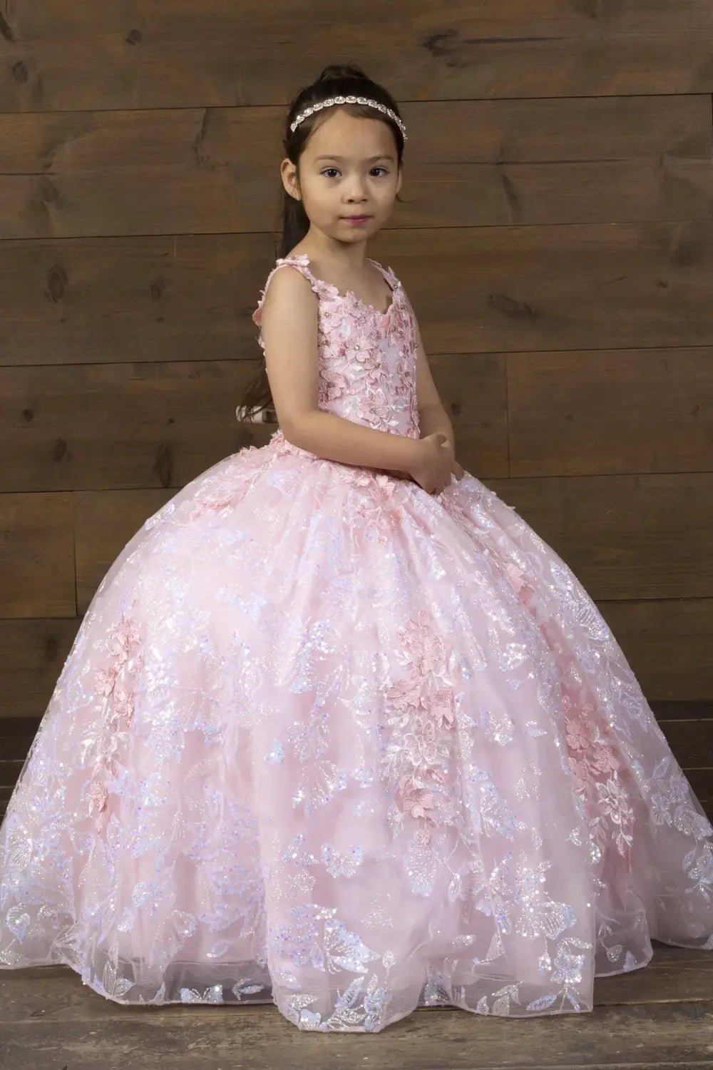 Side view of blush and gold mini quince dress with dimensional 3D floral detail, butterfly embellishments, shimmering glitter tulle, and flowing layered skirt.