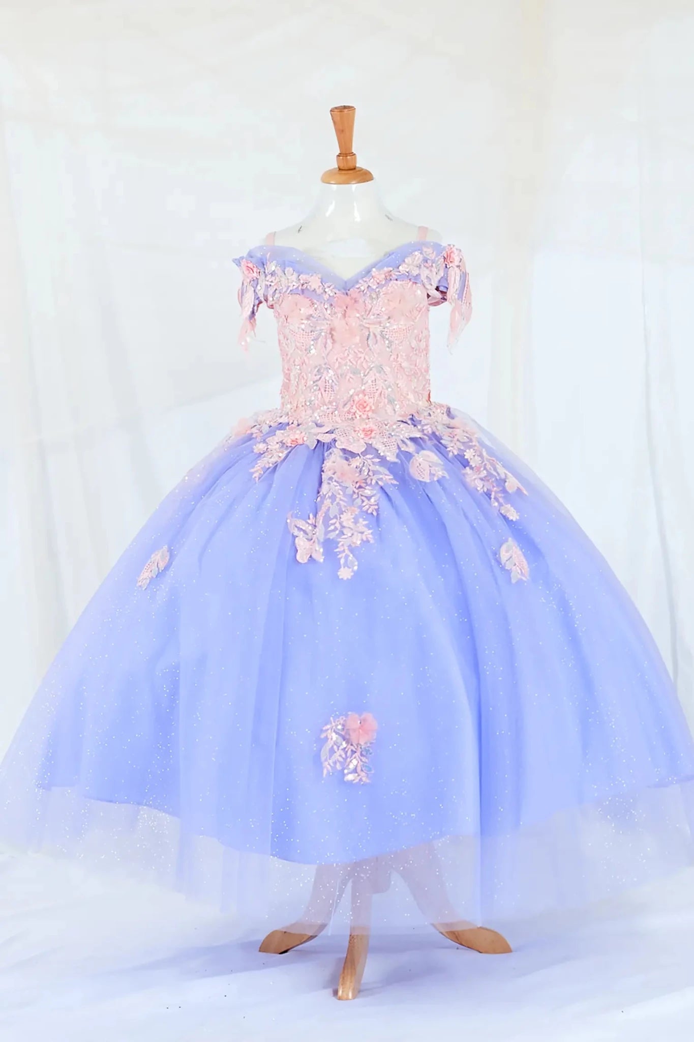 Front-facing display of a glamorous Bahama blue mini quince dress featuring a glitter-embroidered bodice, beaded sleeves, and a voluminous layered skirt.
