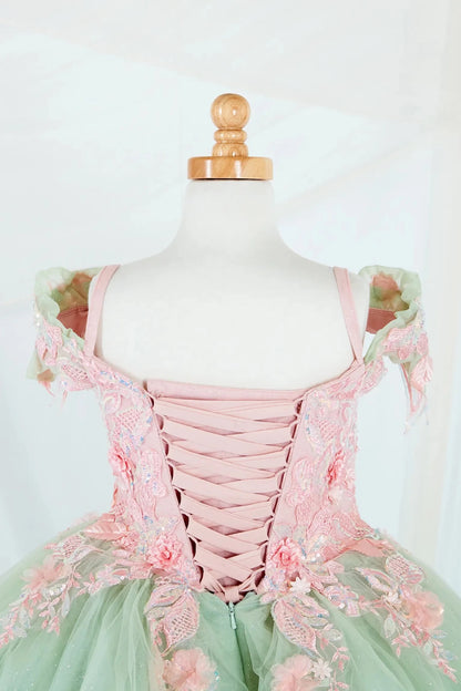 Close-up display highlighting the fitted bodice, detachable bow accent, and the shimmer of the glitter tulle layers. Mini quince dress.