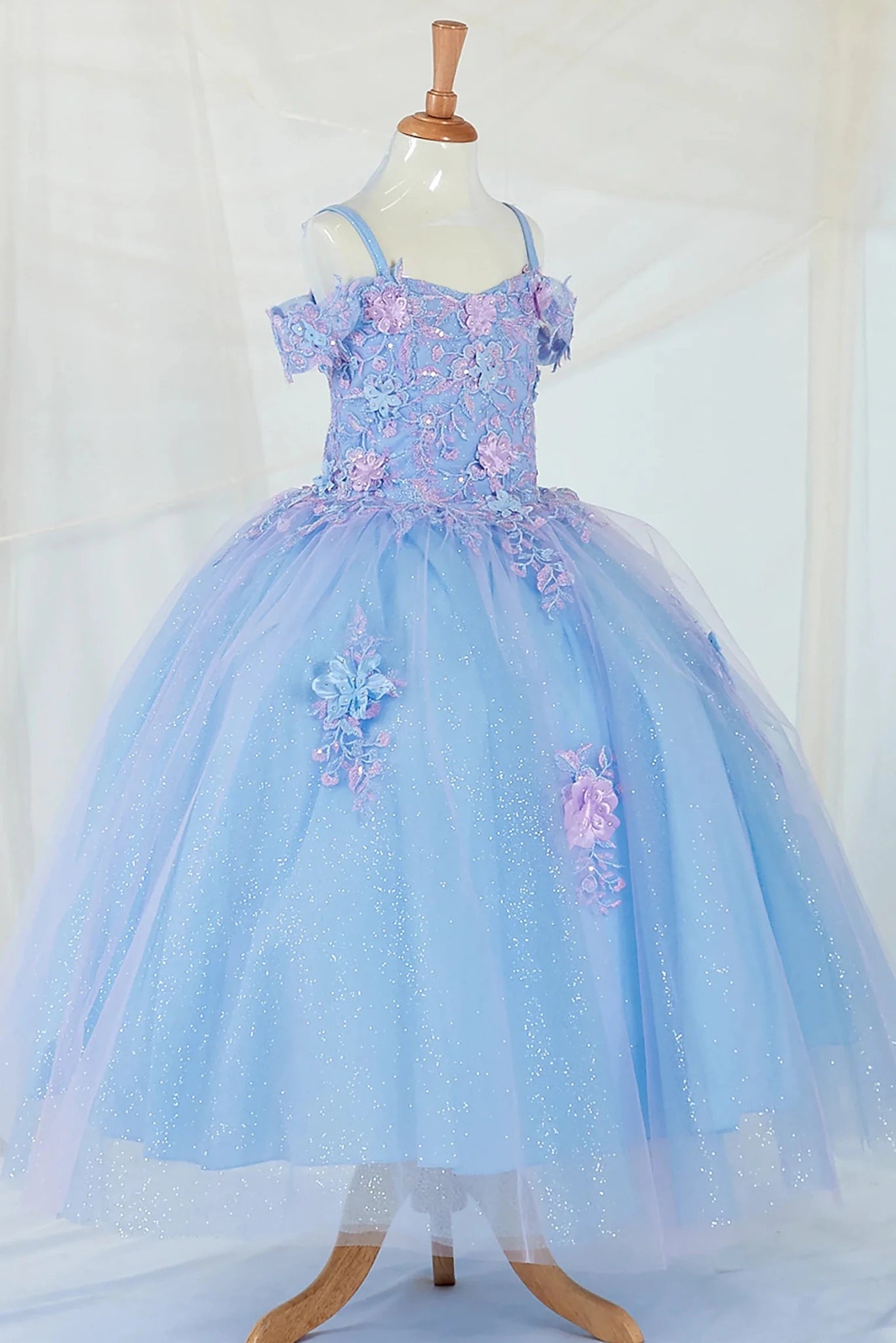 Side-facing display of an elegant light blue and lilac mini quince dress featuring a 3D floral corset bodice and a glitter tulle layered skirt.