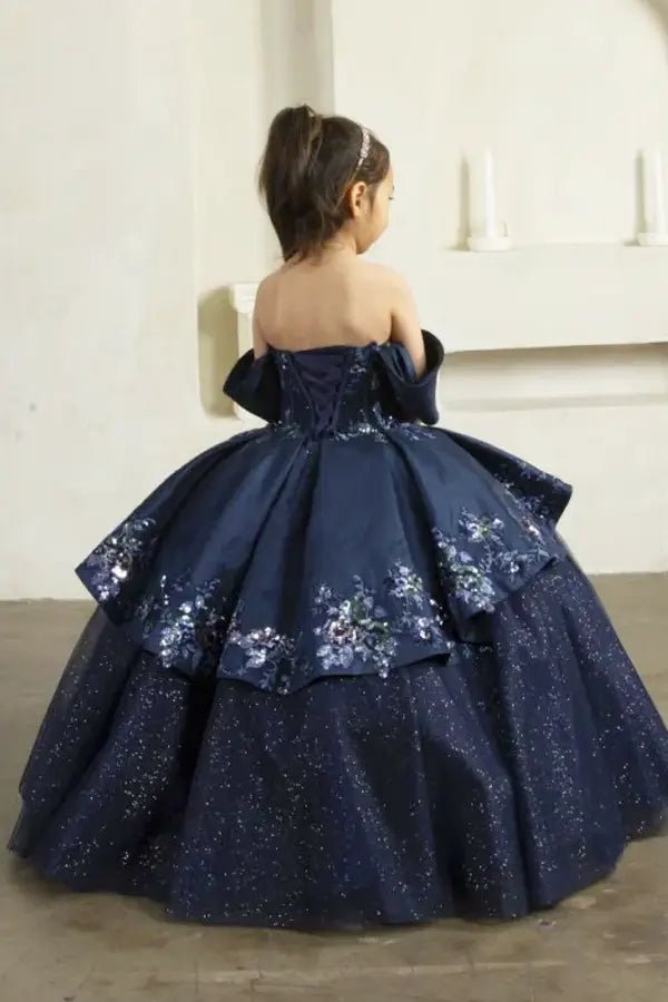 Back view of navy mini quince dress with lace-up corset closure, glitter tulle layers, and cascading full skirt.