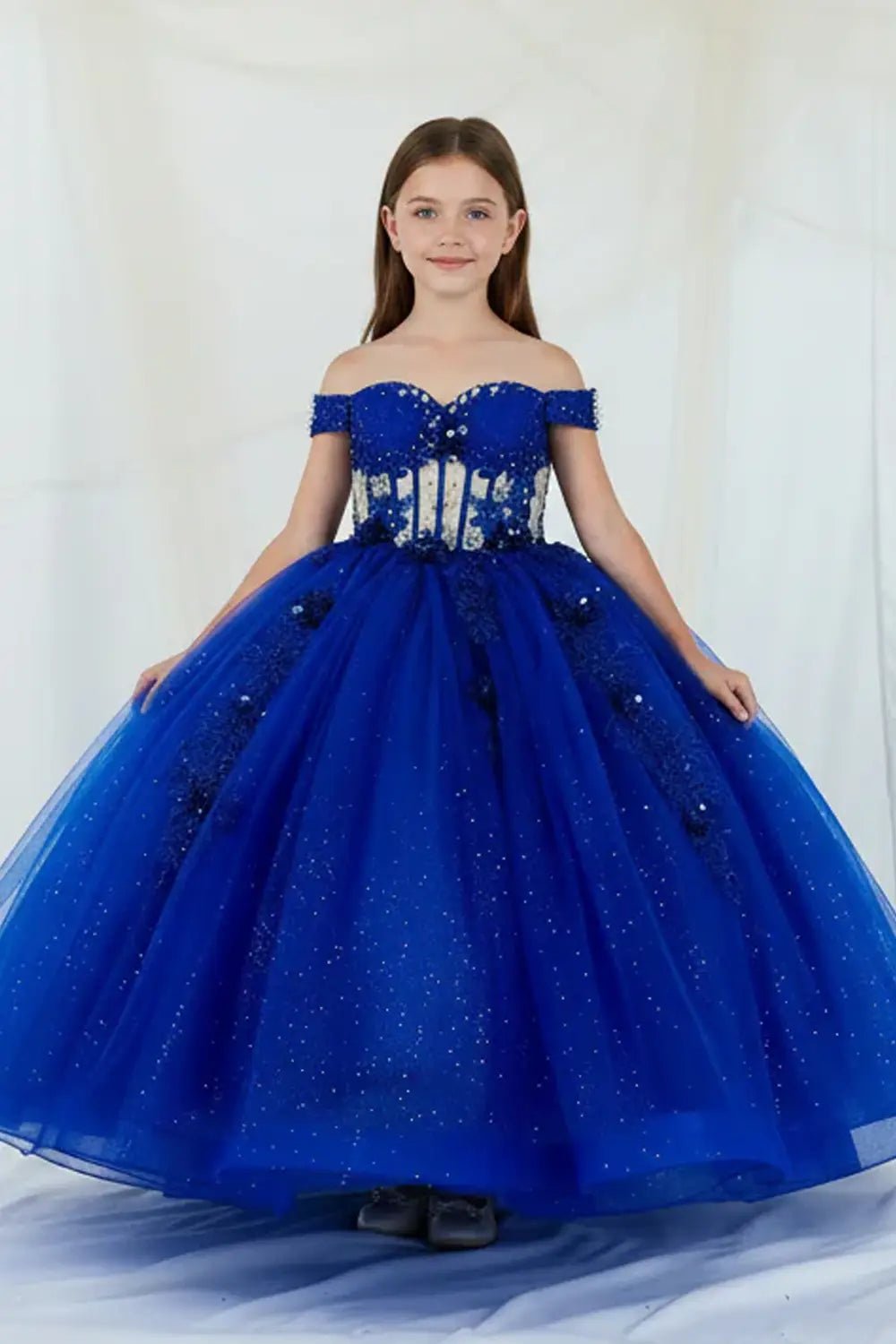 Front-facing view of royal blue mini quince dress with crystal beaded bodice, detachable bow accent, glitter tulle detailing, and sweetheart neckline.