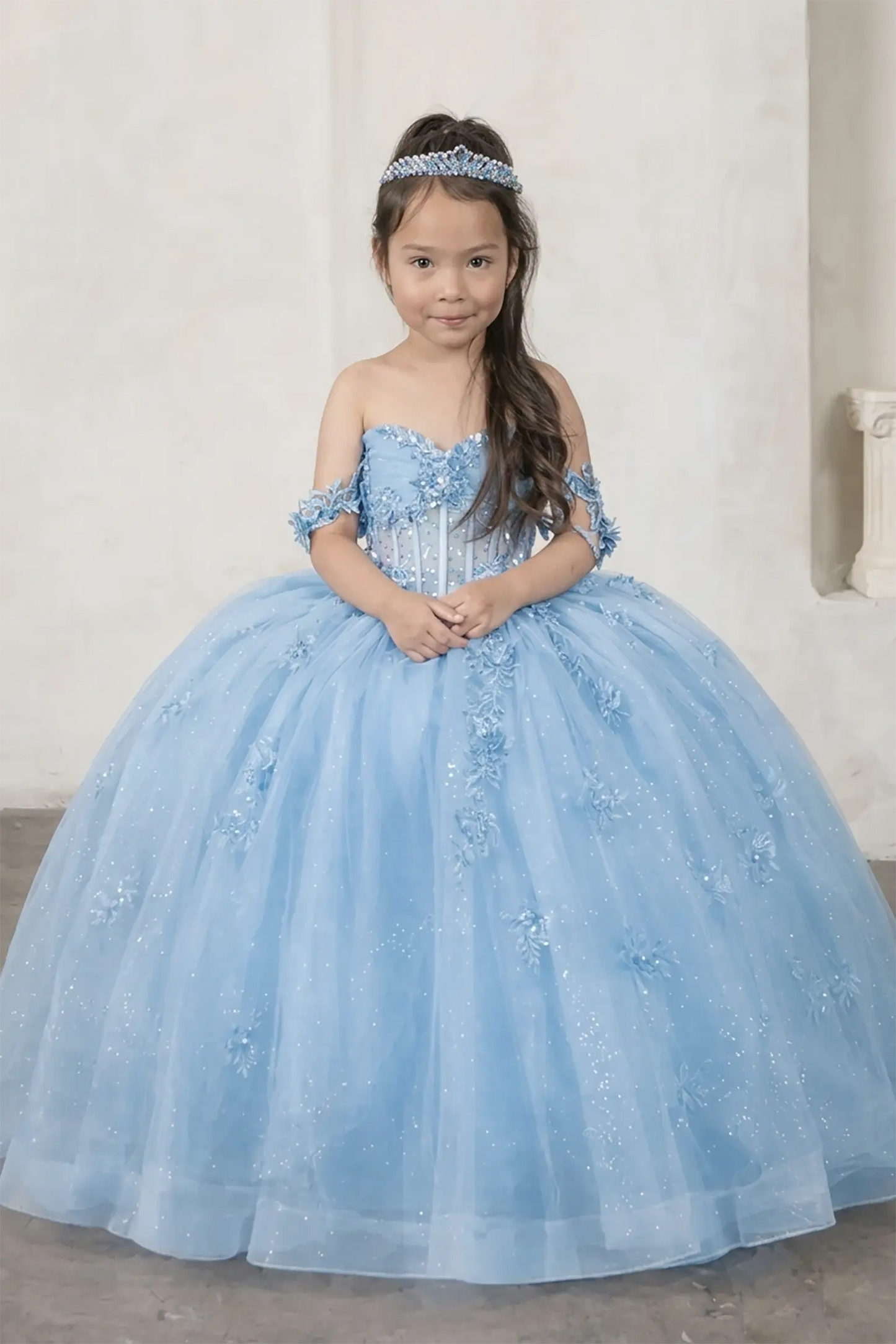 Front view of elegant light blue mini quince dress with crystal beaded bodice, detachable bow accent, and glitter tulle layered skirt.
