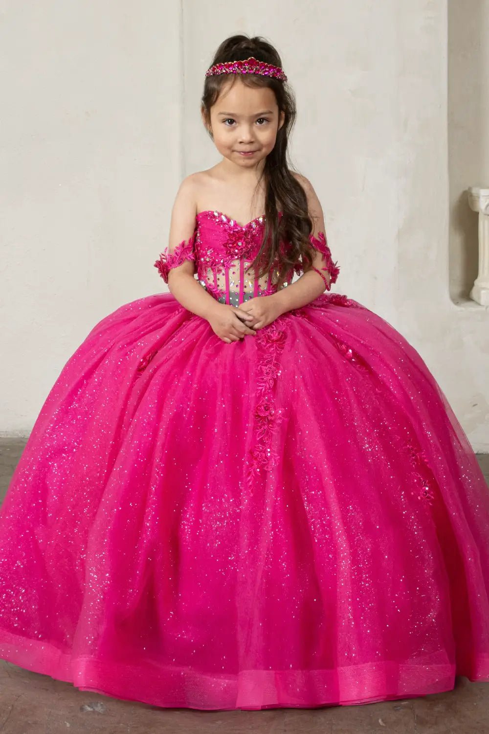 Front view of elegant fuchsia mini quince dress with crystal beaded bodice, detachable bow accent, and glitter tulle layered skirt.