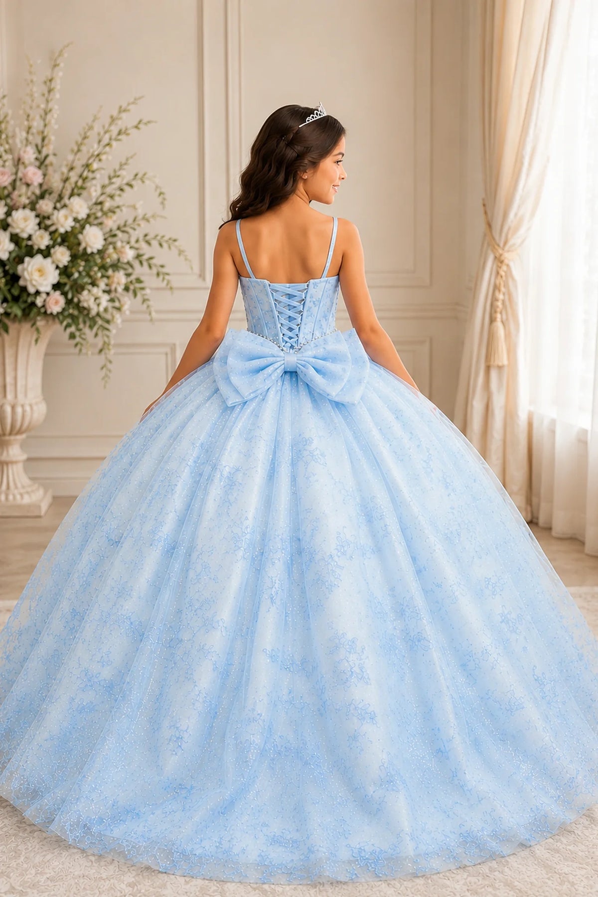 Turning to the back, the Bahama Blue mini quince dress displays its lace-up finish and a-line glitter tulle overlay with a lace-up back.