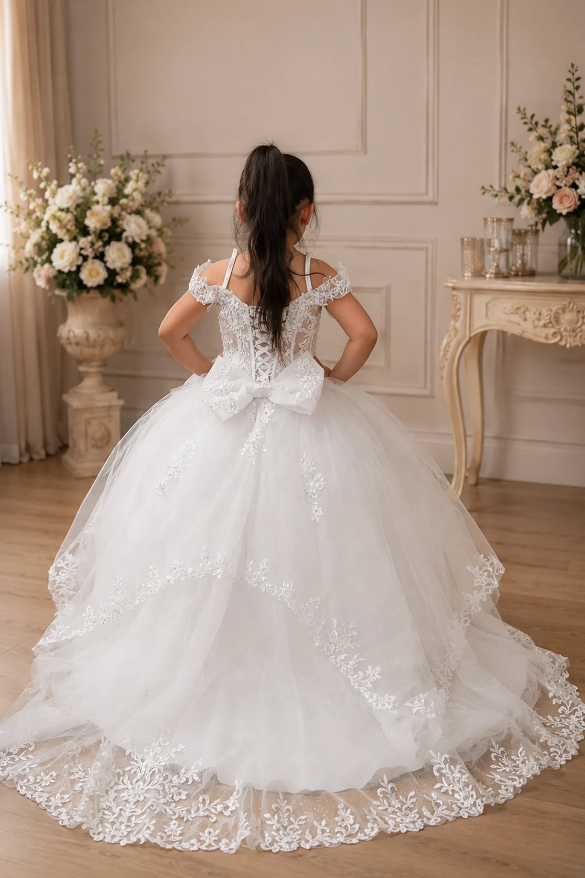 Behind the full skirt, the White mini quince dress displays its lace-up finish and full tulle skirt with a large bow at the back.