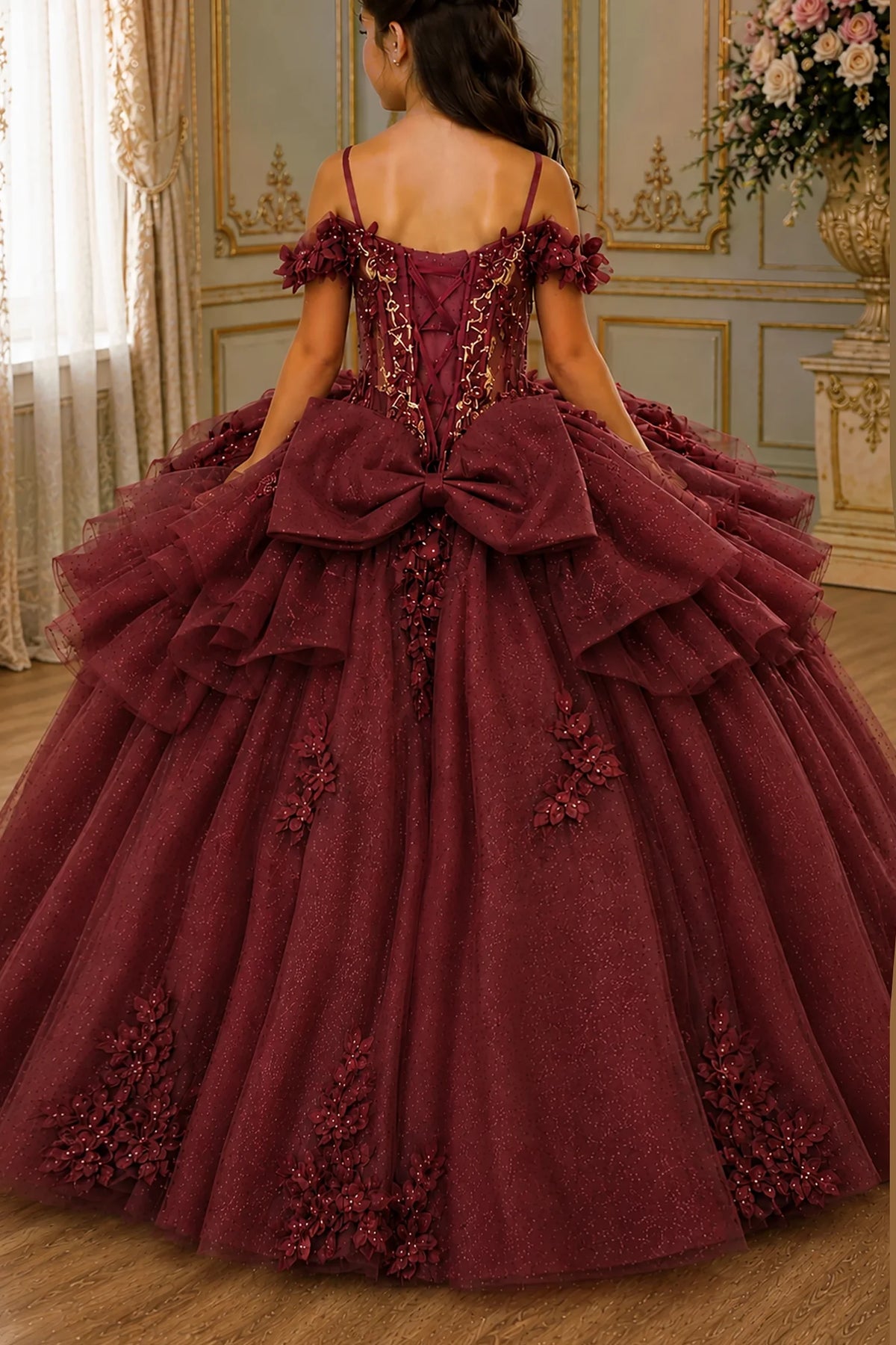 Turning to the back, the Burgundy mini quince dress displays its lace-up finish and floral appliqués over a full tulle ball gown skirt.