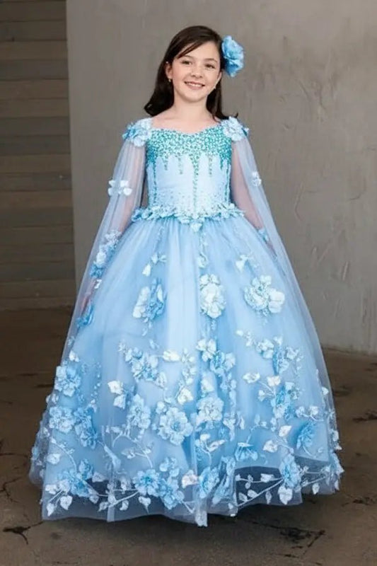 Kid standing front-facing in elegant light blue ball gown with two-tone tail, matching cape, and voluminous skirt