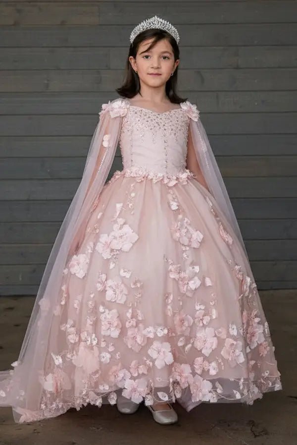 Kid standing front-facing in elegant blush pink ball gown with two-tone tail, matching cape, and voluminous skirt