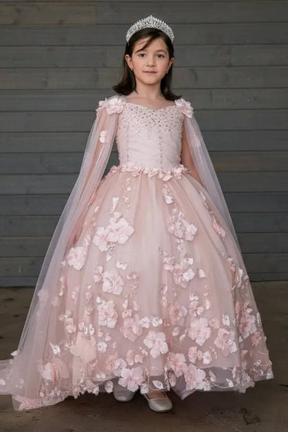 Kid standing front-facing in elegant blush pink ball gown with two-tone tail, matching cape, and voluminous skirt
