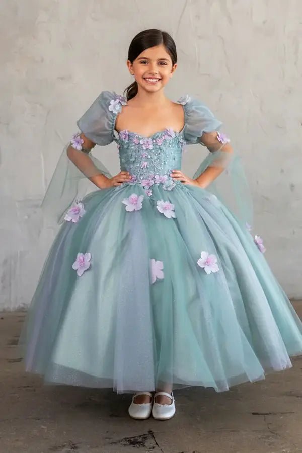 Kid standing front-facing in elegant sage ball gown with 3D flower design, removable sleeves, and voluminous skirt