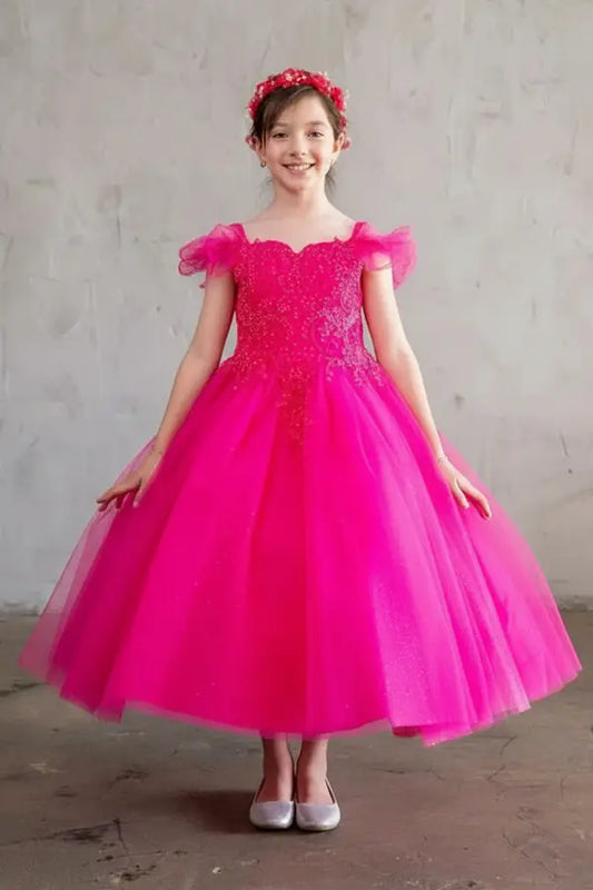 Young woman standing front-facing in exquisite fuchsia ball gown with sequin bodice, matching cape, and voluminous full skirt
