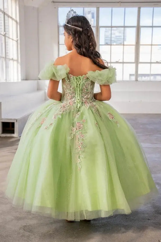 Young woman standing back-facing in lime ball gown with lace-up closure, illusion sweetheart bodice, and cascading full skirt
