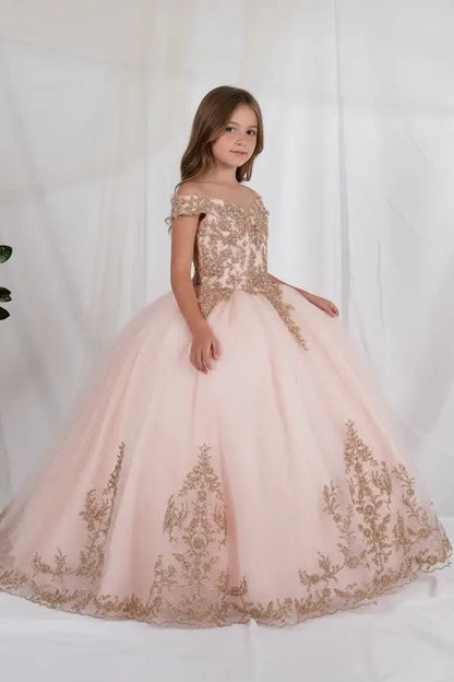Kid standing side-facing in blush ball gown with intricate lace appliqué detail, shimmering glitter tulle, and flowing layered skirt