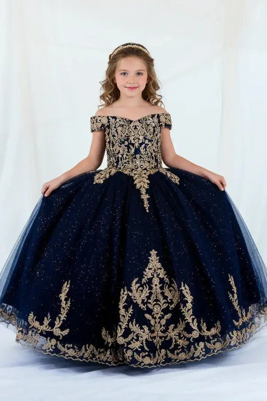 Kid standing front-facing in elegant navy ball gown with lace appliqué bodice and glitter tulle layered skirt