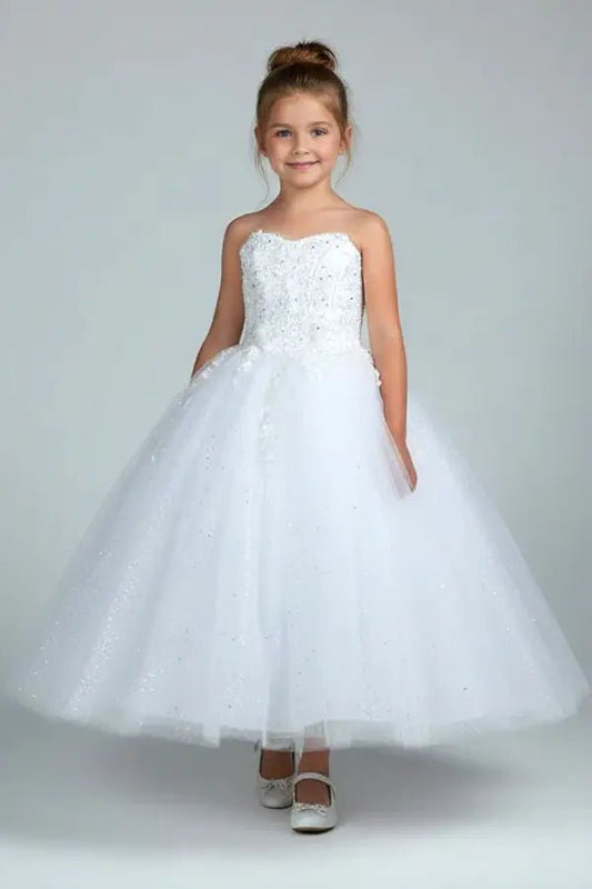 Kid standing front-facing in stunning blush pink ball gown with 3D flower appliqué bodice and glitter tulle layered skirt