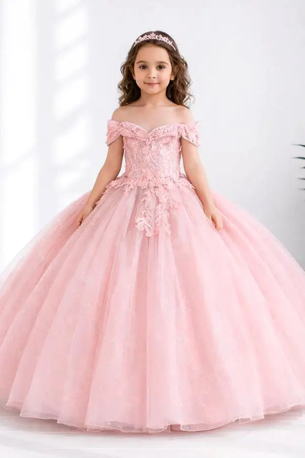 Kid standing front-facing in elegant blush ball gown with fitted bodice, detachable bow accent, and glitter tulle layered skirt