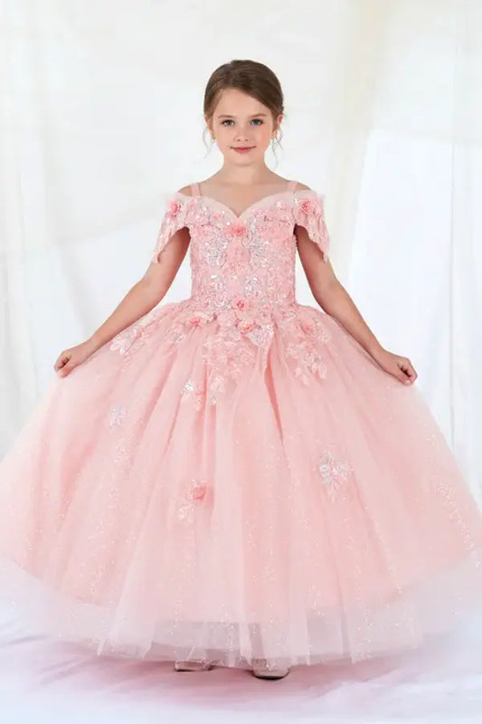 Kid standing front-facing in blush ball gown with detachable bow detail, shimmering glitter tulle, and flowing layered skirt