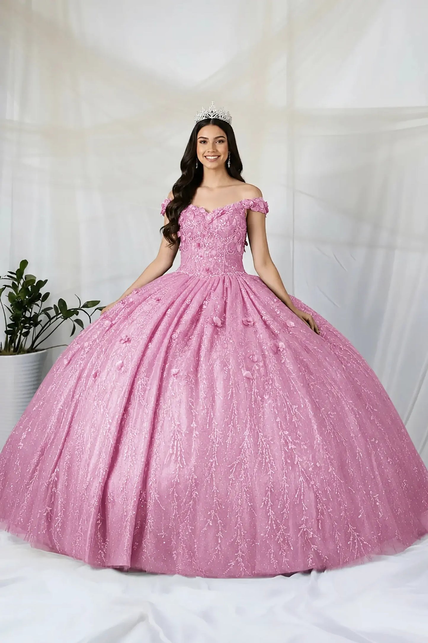 Front view of a dusty rose quinceanera dress with 3D floral appliques, glittered fabric, and detachable sheer flowing cape